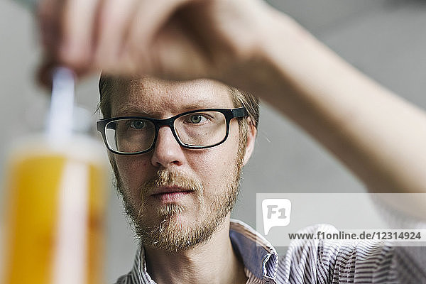 Brewery worker examining beer in beaker