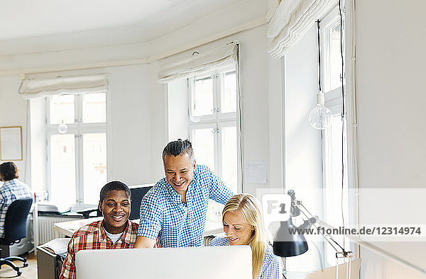 Editors using computer together in office