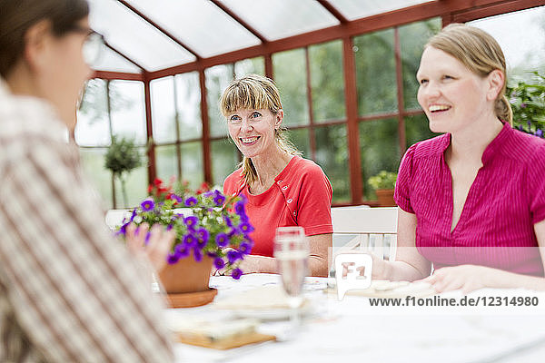 People talking at table in conservatory