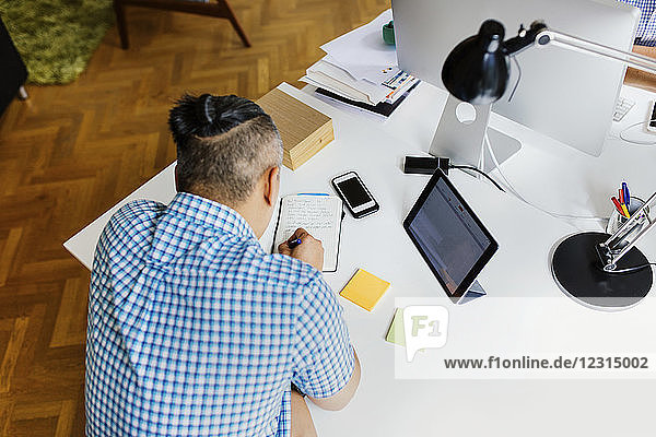 Businessman writing in notepad