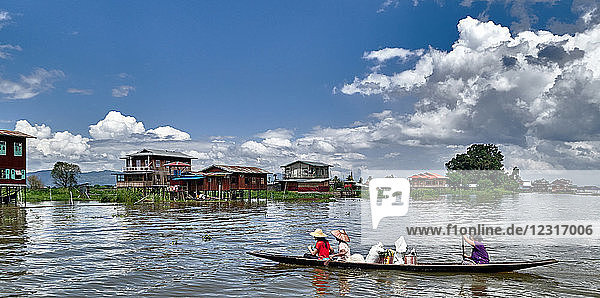 Nam Pan vilage; Shan state  Myanmar (Burma)  Asia ; Stilt houses ; stands in the water ; Local people in a wooden boat paddling on Inle Lake