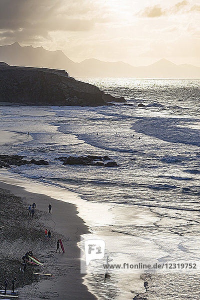 Surfers on Playa del Viejo Rey near La Pared on the volcanic island of Fuerteventura  Canary Islands  Spain  Atlantic  Europe