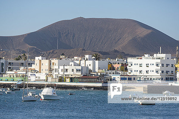 The waterfront of old town Corralejo on the island of Fuerteventura with a volcano in the distance  Fuerteventura  Canary Islands  Spain  Atlantic  Europe