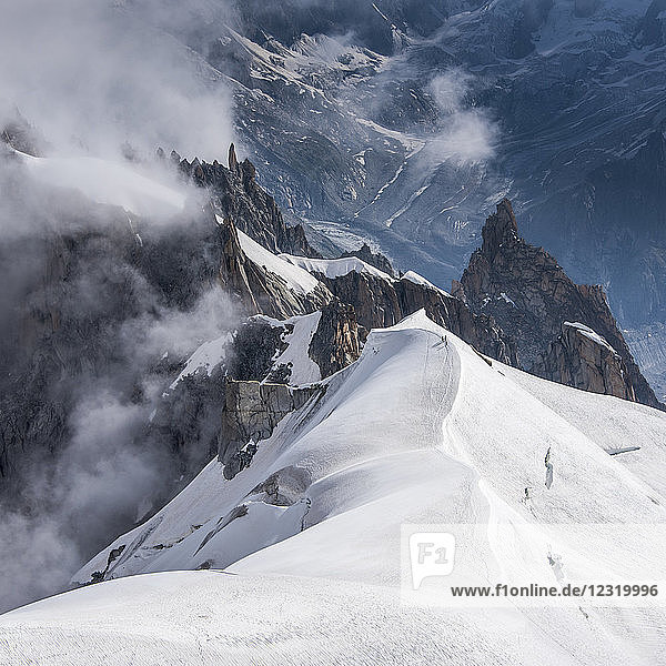Blick über den Grat hinunter ins Vallee Blanche  wo eine kleine Gruppe von Bergsteigern ins darunter liegende Vallee absteigt  Chamonix  Haute Savoie  Rhone Alpes  Frankreich  Europa