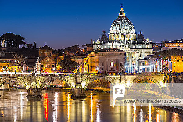 Illuminated St. Peters Basilica and the Vatican with Ponte St Angelo over the River Tiber at dusk  Rome  Lazio  Italy  Europe
