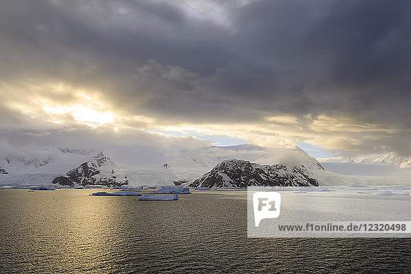 Sonnenaufgang  mit atmosphärischen Wolken und Nebel  Berge  Gletscher und Eisberge  Neko Harbour  Andvord Bay  Graham Land  Antarktis  Polarregionen