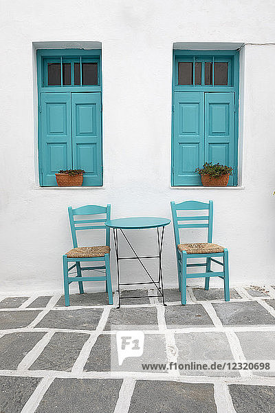 Tisch und Stühle eines typisch griechischen Cafés mit verschlossenen Fenstern  Pano Chora  Serifos  Kykladen  Ägäisches Meer  Griechische Inseln  Griechenland