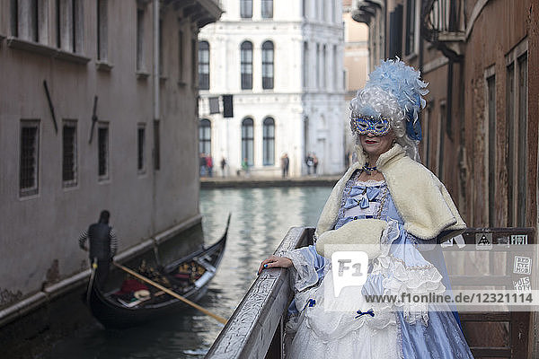 Dame im Karnevalskostüm von Venedig mit Gondel im Hintergrund  Venedig  UNESCO-Weltkulturerbe  Venetien  Italien  Europa