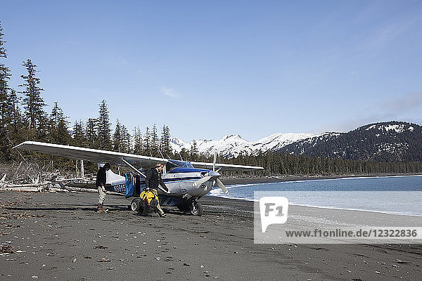 Surfer entladen ihre Ausrüstung aus einer Cessna 206 an der Außenküste der Kenai-Halbinsel  Süd-Zentral-Alaska; Alaska  Vereinigte Staaten von Amerika
