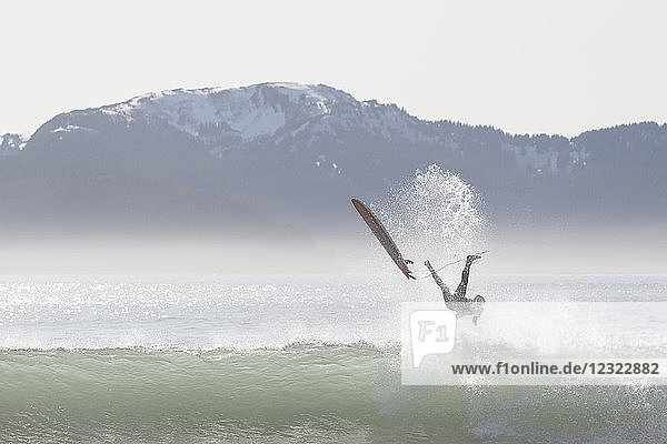 Ein Surfer wird von einer Welle an der Außenküste der Kenai-Halbinsel  Süd-Zentral-Alaska  USA  abgeworfen.