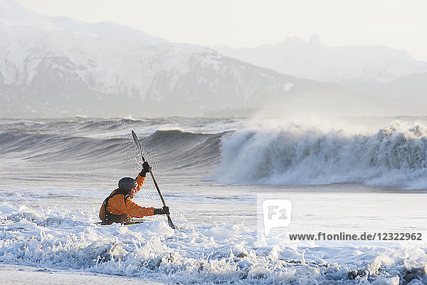 Kayak surfer paddling through rough waters  Kachemak Bay  South-central Alaska; Homer  Alaska  United States of America