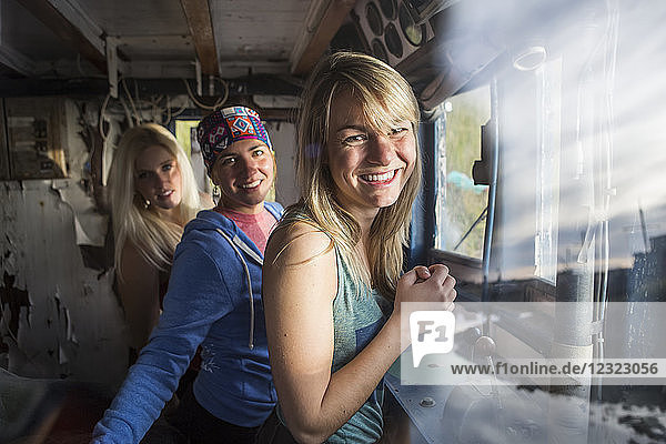 Drei junge Frauen hängen in einem verlassenen alten Schiff an der Küste von Homer  Süd-Zentral-Alaska  ab; Homer  Alaska  Vereinigte Staaten von Amerika