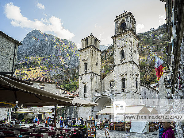 Touristen in den Straßen von Kotor mit Restaurantterrassen und einem Kirchengebäude mit zwei Türmen; Kotor  Gemeinde Kotor  Montenegro