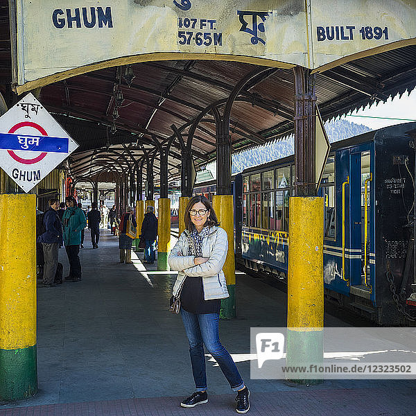 Eine Frau steht an einem Bahnhof für den Darjeeling Toy Train  Darjeeling Himalayan Railway; Ghoom  Westbengalen  Indien