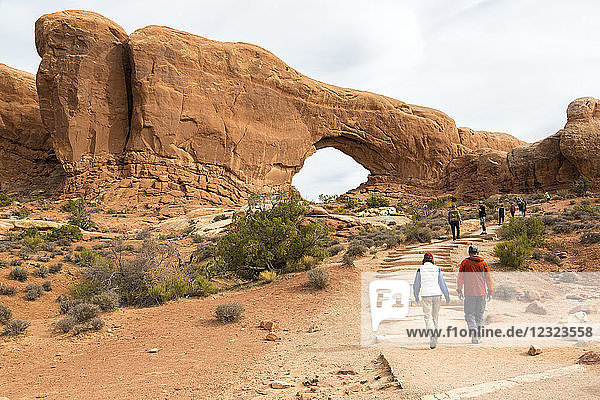 Zwei Wanderer nähern sich dem Window Arch  Arches National Park  Utah  Vereinigte Staaten von Amerika