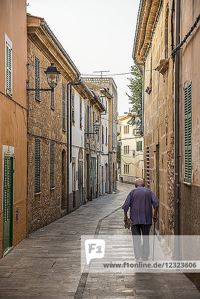 Senior man walking in the streets of Alcudia; Alcudia  Mallorca  Balearic Islands  Spain