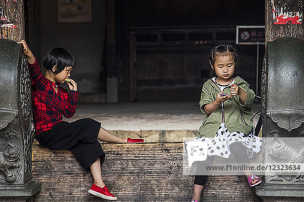 Two young girls in the Eryi Building  Dadi Tulou; Fujian  China
