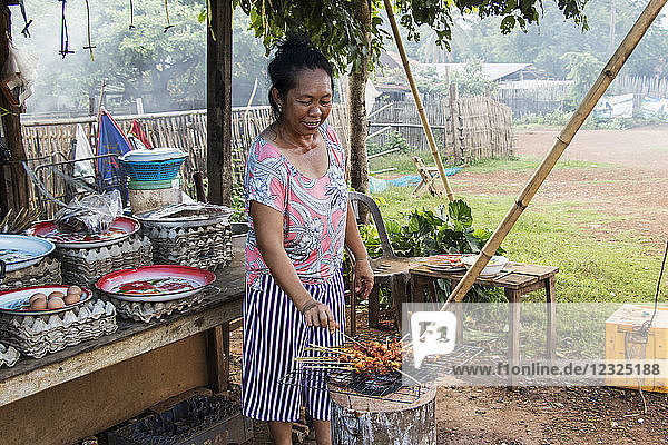 Frau beim Grillen von Satay  Pha Suam  Bolaven Plateau; Champasak  Laos