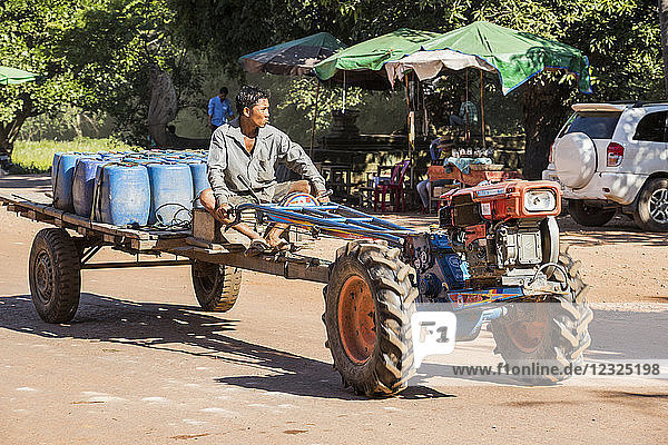 Mann fährt auf einem Traktor die Straße entlang  Beng Meala; Siem Reap  Kambodscha