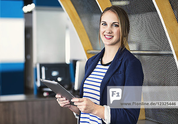 Porträt einer jungen Geschäftsfrau  die Technologie am Arbeitsplatz nutzt; Sherwood Park  Alberta  Kanada