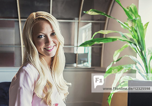 Business-Porträt einer schönen jungen Geschäftsfrau mit langen blonden Haaren am Arbeitsplatz; Sherwood Park  Alberta  Kanada