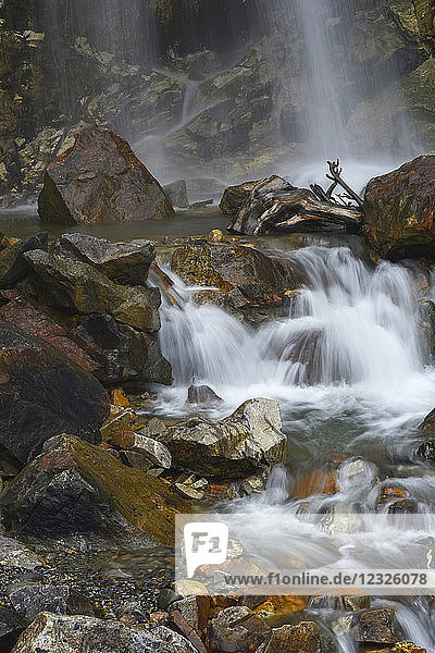 Bewegungsunschärfe eines Wasserfalls  der in ein Becken plätschert und über Felsen kaskadiert; Alaska  Vereinigte Staaten von Amerika