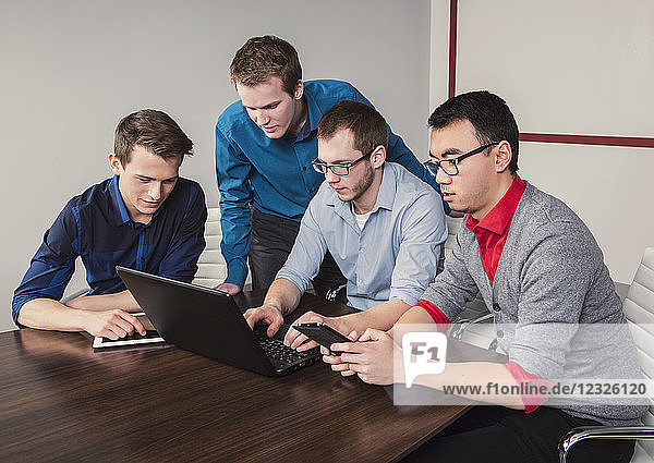 Junge Männer der Jahrtausendwende  die in einem Konferenzraum in einem modernen Hightech-Unternehmen zusammenarbeiten; Sherwood Park  Alberta  Kanada