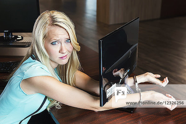 Junge Geschäftsfrau der Jahrtausendwende  gefesselt an ihren Computerbildschirm am Arbeitsplatz; Sherwood Park  Alberta  Kanada