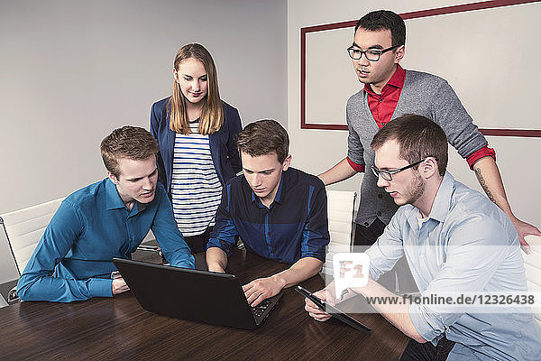 Junge Geschäftsleute der Jahrtausendwende arbeiten in einem Konferenzraum in einem modernen Hightech-Unternehmen zusammen; Sherwood Park  Alberta  Kanada