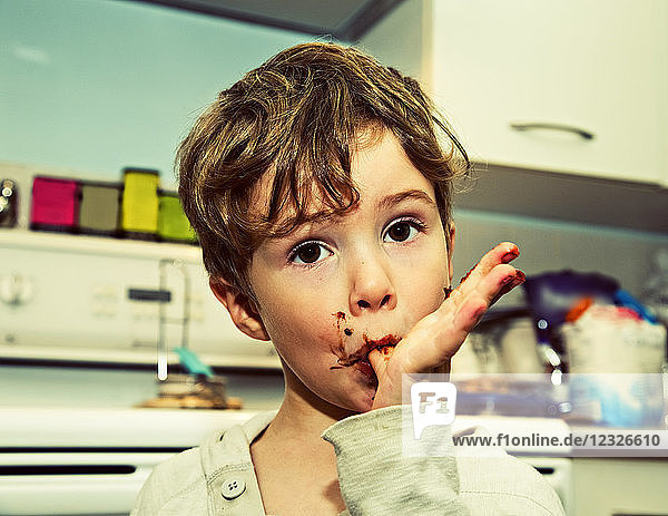 Ein kleiner Junge leckt sich die Finger nach der Herstellung von Fudge; Langley  British Columbia  Kanada