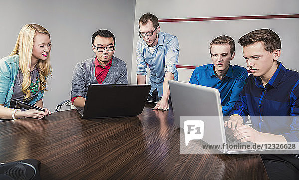 Junge Geschäftsleute der Jahrtausendwende arbeiten in einem Konferenzraum in einem modernen Hightech-Unternehmen zusammen; Sherwood Park  Alberta  Kanada
