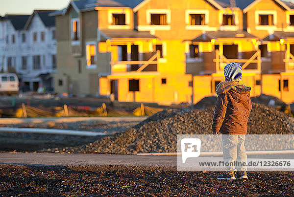 Ein kleiner Junge sieht sich den Bau eines neuen Hauses in seiner Nachbarschaft an; Langley  British Columbia  Kanada