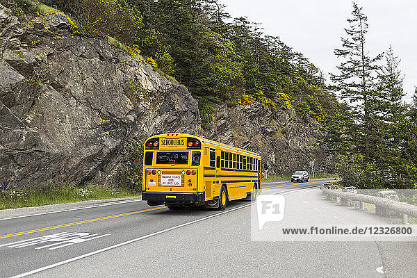 Ein gelber Schulbus und ein Auto auf einer Highway-Brücke über den Deception Pass  Whidbey Island; Washington  Vereinigte Staaten von Amerika