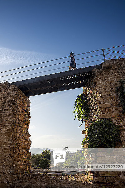 Tourist walking over the city wall; Alcudia  Mallorca  Balearic Islands  Spain