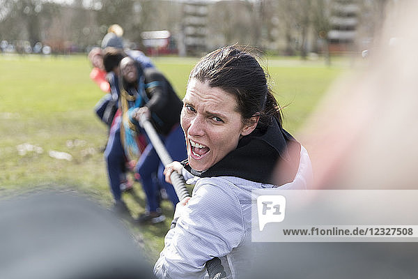 Determined woman enjoying tug-of-war in park