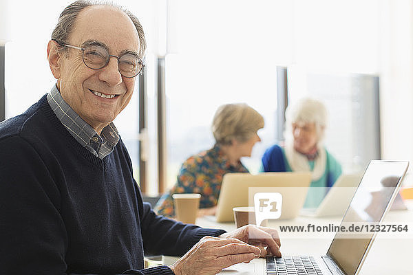 Portrait smiling  confident senior businessman using laptop in conference room meeting