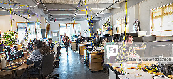 Creative business people working in open plan office