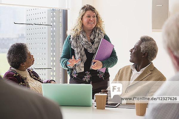 Smiling businesswoman leading conference room meeting