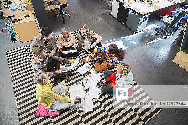 Creative business team meeting  brainstorming in circle on floor in office