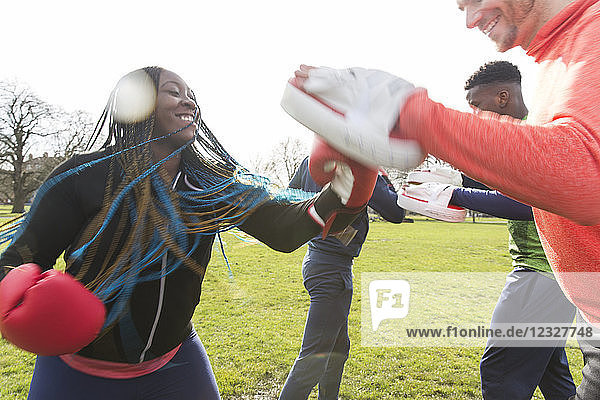 Smiling woman boxing in park