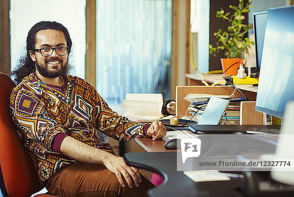 Portrait smiling  confident creative businessman working at desk