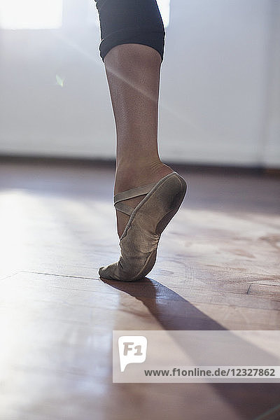 Close up young female ballet dancer practicing in ballet shoe