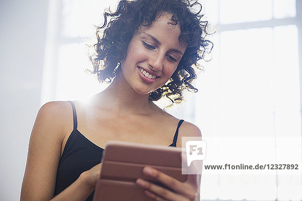 Lächelnde junge Frau mit digitalem Tablet