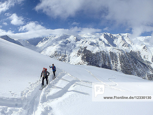 Österreich  Tirol  Sellraintal  2 Männer auf Langlaufskiern bewegen sich im Neuschnee in Richtung Schafkogelpass mit toller Aussicht auf die Stubaier Alpen