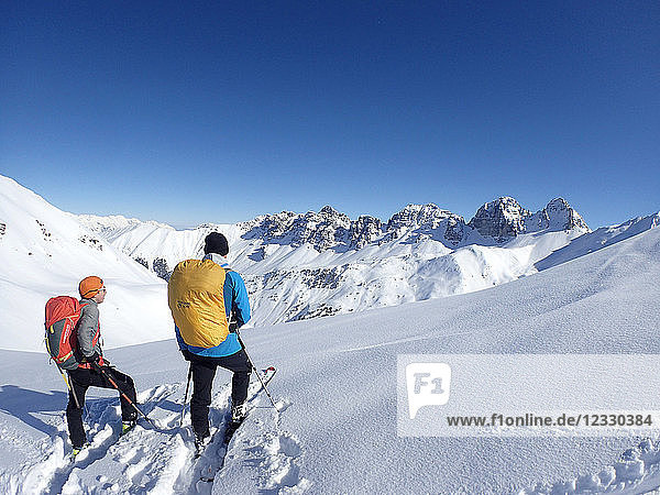 Austria  Tirol  Sellrain valley  2 men on nordic skiing are posing in front of the Kalkkoegel mountain range on the Schafkogel pass