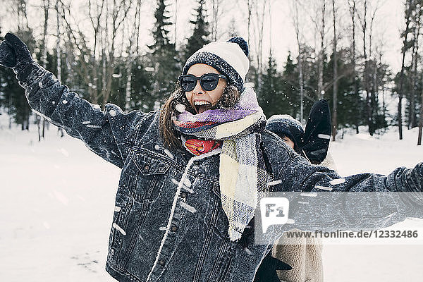 Happy woman enjoying with friend at snowy field