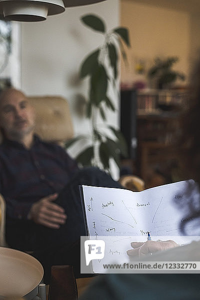 Therapist holding paper while discussing with patient during session