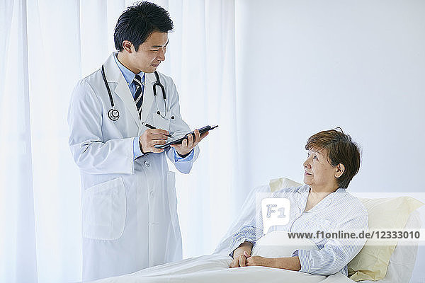 Japanese doctor with a patient in bed