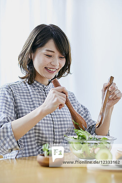 Junge Japanerin isst Salat