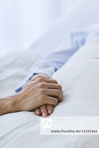 Halten der Hand eines Patienten im Bett